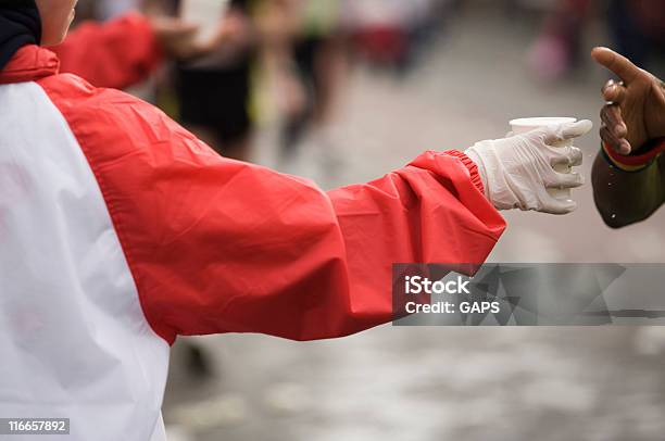 Executando O Atleta Africana Agarrando Uma Bebida - Fotografias de stock e mais imagens de Oferecer - Oferecer, Água, Maratona