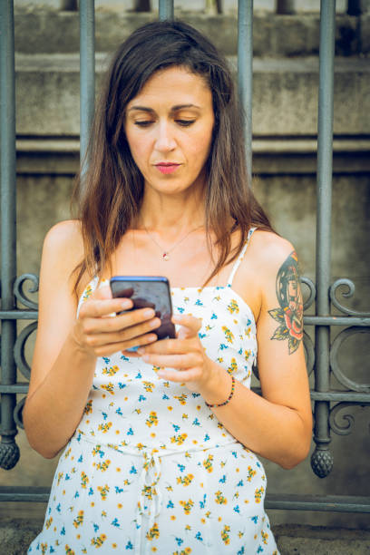 istock Pretty woman using smart phone at the street 1166579265