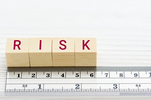 Risk assessment / risk scale analysis and management concept : Words RISK on wood blocks and a ruler, depict uncertainty financial risk or credit profile an investor involved in a trading stock market