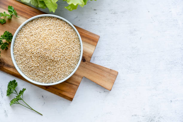 Dry white quinoa seeds in a bowl. Dry white quinoa seeds in a bowl. Healthy vegetarian food, gluten free, balanced diet concept. quinoa photos stock pictures, royalty-free photos & images