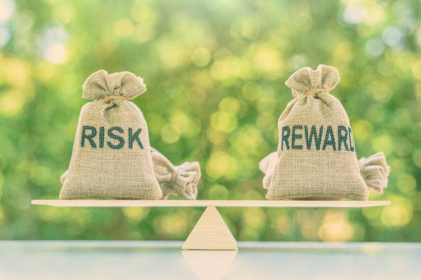 istock Risk reward ratio / risk management concept : Risk and reward bags on a basic balance scale in equal position, depicts investors use a risk reward ratio to compare the expected return of an investment 1166581794