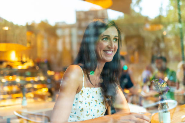 istock Beautiful woman having coffee behind a restaurant window 1166582241