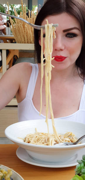 istock Woman eating spaghetti 1166582875