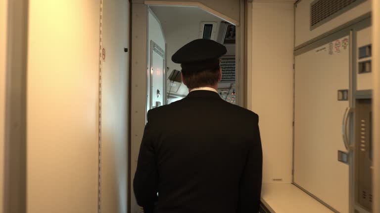 Back view of captain walking into the cockpit