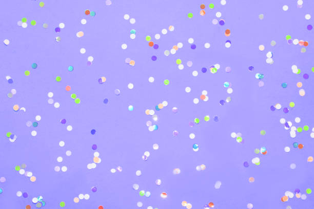 istock Colored confetti scattered on purple pastel paper 1166583303