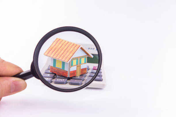 observing houses and calculators in a white background with a magnifying glass - immovable imagens e fotografias de stock