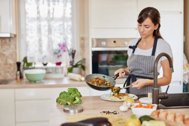 istock Woman putting sauce on spaghetti. 1166584103