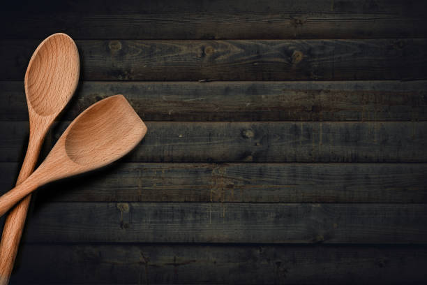 istock Wooden kitchenware spoon on dark wooden cutting board or desk table top view flat lay background 1166585419