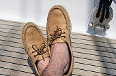 Man wearing boes shoes on sailboat deck