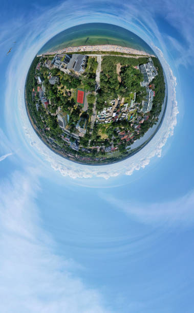 istock Drone aerial panoramic 360 degree view on sunny beach with sunbathers with windbreaks and towels at sea in touristic city 1166588965