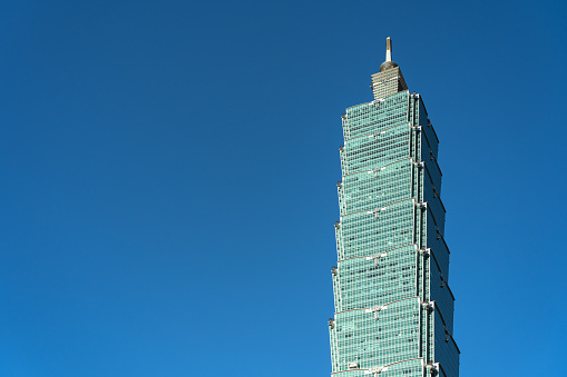 Taipei 101 skyscraper building close up view over dark blue sky. formerly known as the Taipei World Financial Center. A landmark supertall skyscraper in Xinyi District, Taipei, Taiwan