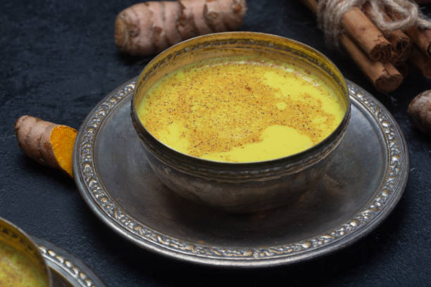 istock Golden turmeric milk on the black background with ingredients 1166593133