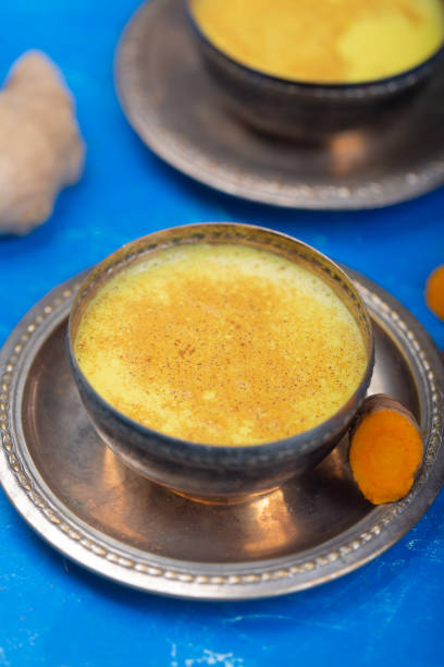istock Golden turmeric milk on the blue background with ingredients 1166593134