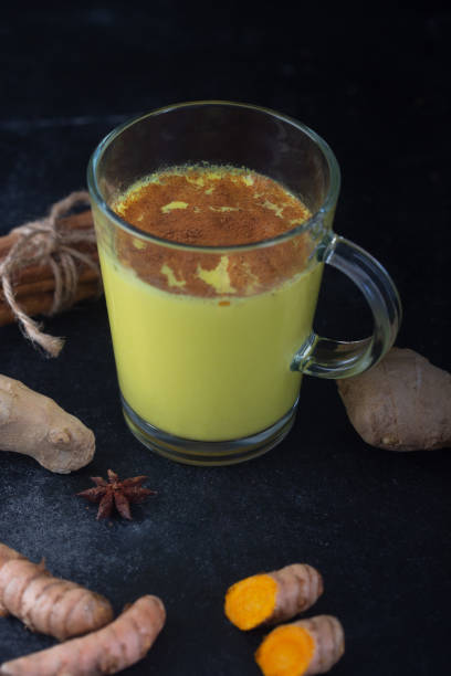 istock Golden turmeric milk on the black background with ingredients 1166593152