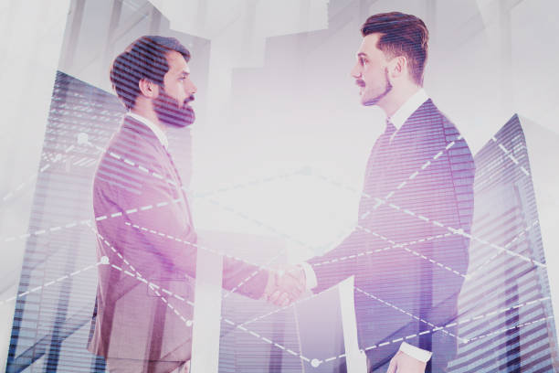 istock Two men shaking hands in city, graphs 1166598381