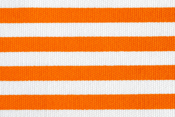 istock Textile background with orange and white stripes. Fabric texture 1166598548