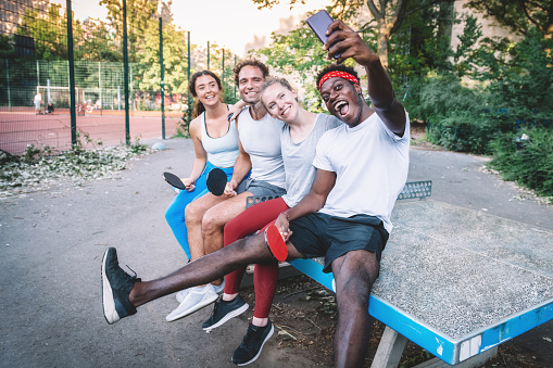 happy young sports people taking selfie on ping-pong table in Berlin