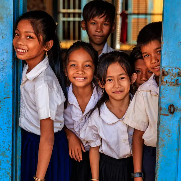 Cambodian school children standing in doorway of classroom in small village near Tonle Sap, Cambodia.