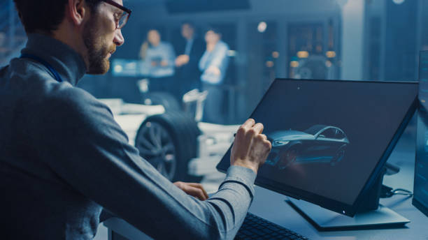 istock Professional Automotive Graphic Designer is Working on Concept Car Render with a Stylus Pen in a High Tech Innovative Laboratory with a Prototype Car Chassis. 1166603963