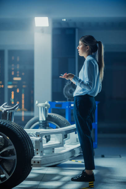 Automotive Design Engineer Thinking About Electric Car Chassis Prototype. In Innovation Laboratory Facility Concept Vehicle Frame Includes Wheels, Suspension.
