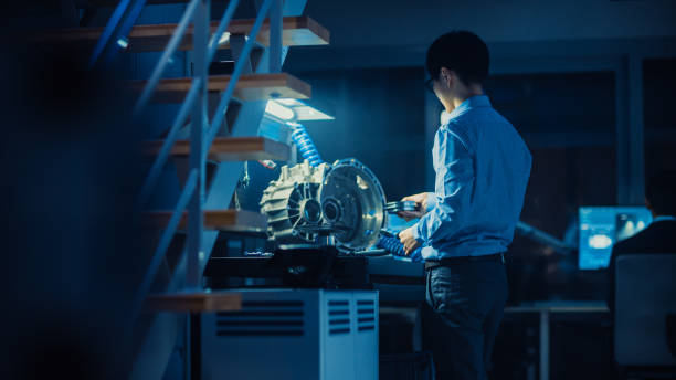istock Professional Automotive Engineer in Glasses is Working on Transmission Gears in a High Tech Innovative Laboratory with a Computer Screens. 1166603996