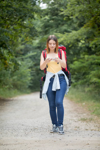 istock Cute female hiker using mobile phone 1166604032