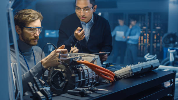 istock Two Professional Automotive Engineers with a Tablet Computer and Inspection Tools are Having a Conversation While Testing an Electric Engine in a High Tech Laboratory with a Concept Car Chassis. 1166604578