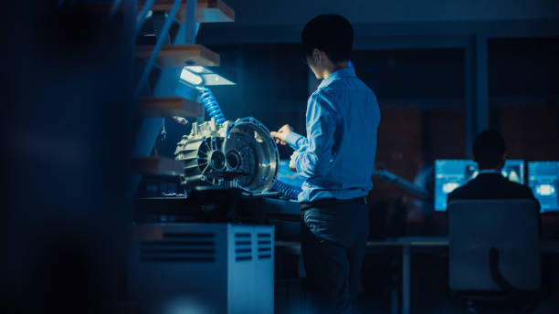 istock Professional Automotive Engineer in Glasses is Working on Transmission Gears in a High Tech Innovative Laboratory with a Computer Screens. 1166604602
