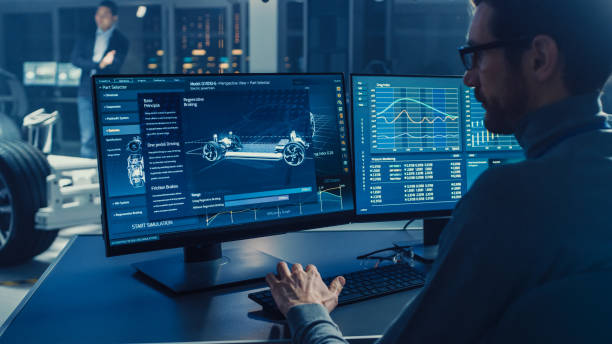 istock Professional Engineer Works on a Computer with a 3D CAD Software and Tests the Electric Car Chassis Prototype with Wheels, Batteries and Engine Standing in a High Tech Development Laboratory. 1166604634
