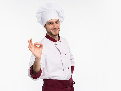 Positive professional happy man chef showing tasty ok sign isolated on white background