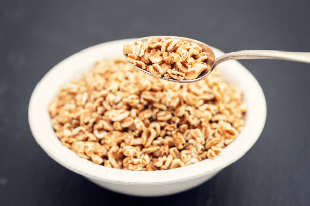 istock puffed spelt in white bowl on black ceramic background 1166605610