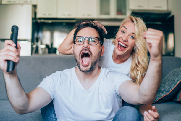 Young couple watching sport on tv.