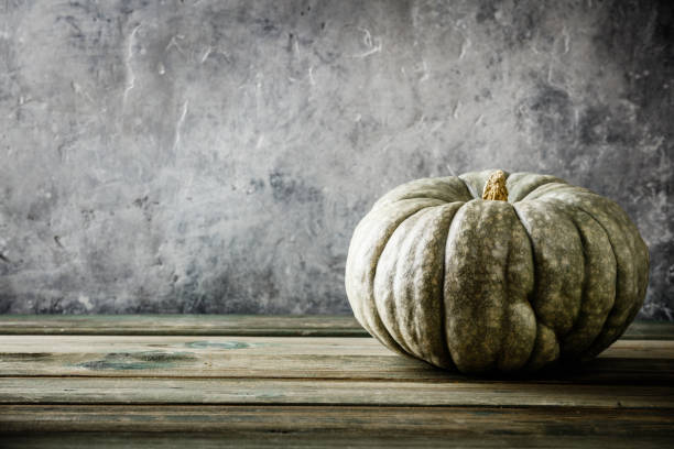 istock Autumn background with pumpkin on wooden tabel against old rust condition vintage wall 1166608009