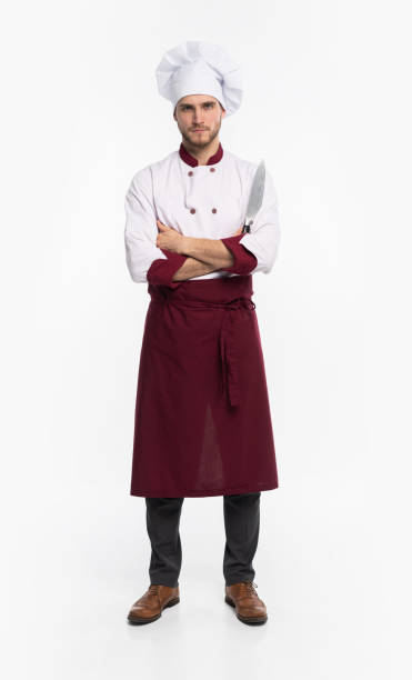 istock Positive handsome chef cook in beret and white outfit isolated on white background. 1166608426