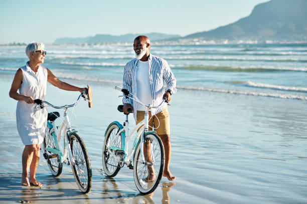 c'était la date parfaite - senior couple cycling beach bicycle photos et images de collection