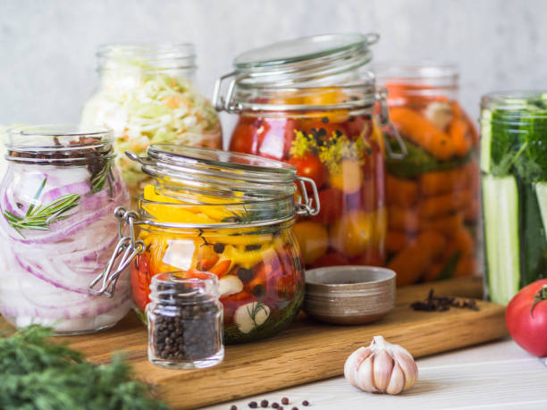 istock Cooking pickled vegetables. Salting various vegetables in glass jars for long-term storage. Preserves vegetables in glass jars. Variety fermented green vegetables on wood board 1166609649