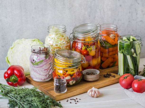 istock Cooking pickled vegetables. Salting various vegetables in glass jars for long-term storage. Preserves vegetables in glass jars. Variety fermented green vegetables on wood board 1166609715