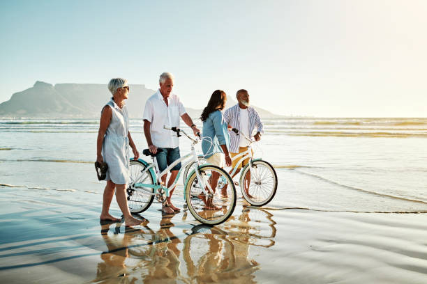 vivez votre vie par des souvenirs et non par des chiffres - senior couple cycling beach bicycle photos et images de collection