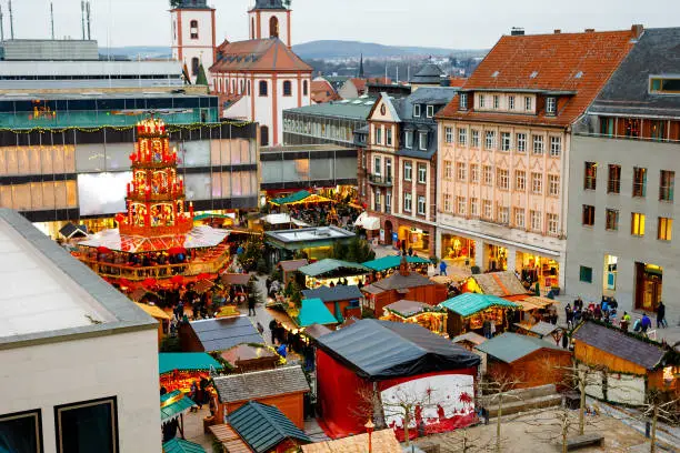 Photo of Traditional christmas market in the historic center of Nuremberg, Germany. Decorated with garland and lights sale stalls with sweets, mulled wine and Xmas decoration and German gifts.