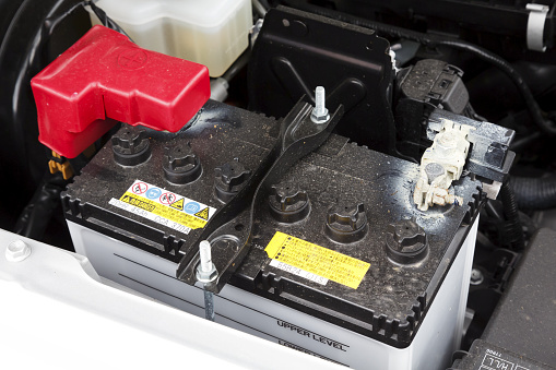 Buckingham, UK - May 16, 2019. Car battery is fitted in a car engine compartment of a Suzuki Jimny. The lead acid car battery is designed for easy replacement.