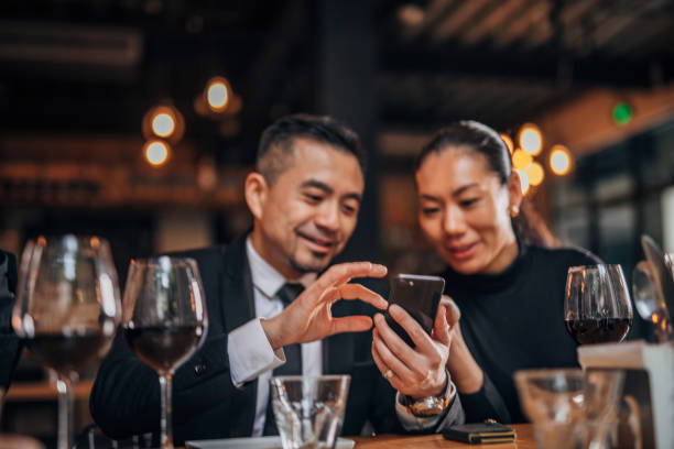 istock Man and lady using smart phone in restaurant 1166617285