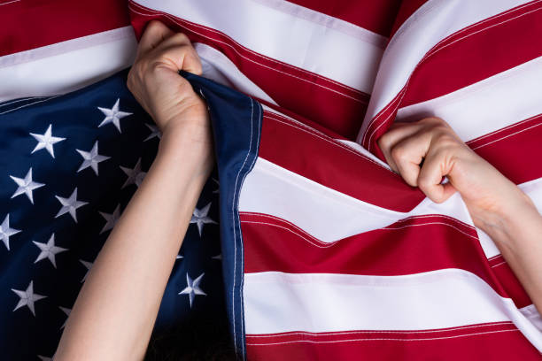 istock Young woman hands pull USA American flag 1166618519