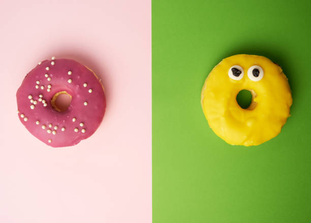 istock two round donuts with sprinkles on a pink-green background 1166618941