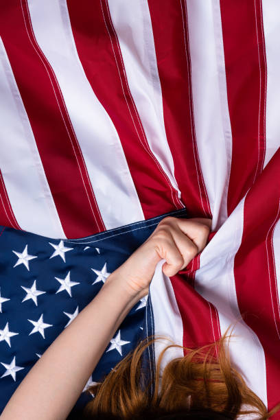 istock Young woman hand pull USA american flag 1166620181