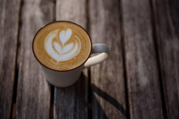 istock Heart shape coffee art in white cup on wooden table 1166622207