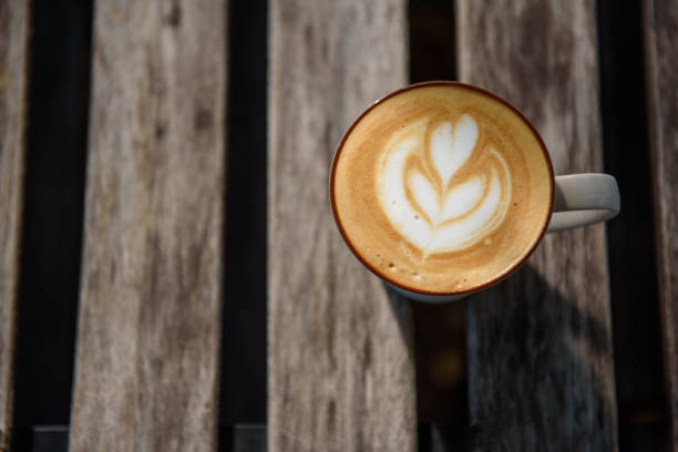 istock Heart shape coffee art in white cup on wooden table 1166622236