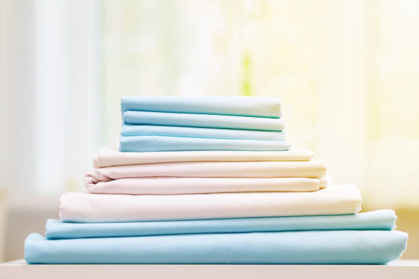 istock Closeup stack of blue and white clean bedding on the table. Blurred background. 1166622433