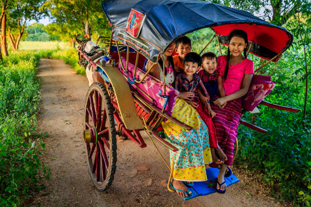 Burmese children sitting on a horse cart, Bagan, Myanmar Burmese children with thanaka sitting on a horse cart near the ancient temples of Bagan, Myanmar (Burma) bagan archaeological zone stock pictures, royalty-free photos & images