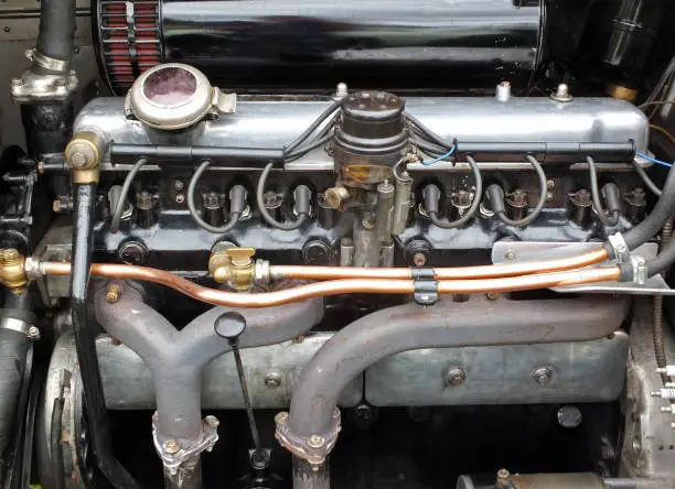 close up of a large vintage six cylinder petrol engine in an old fashioned sports car