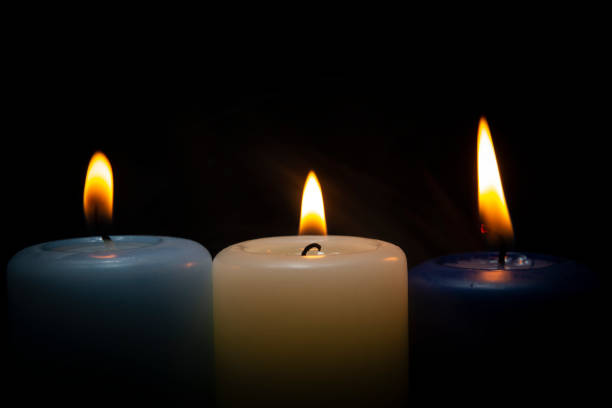 Close up of three colorful wax candles flame stock photo